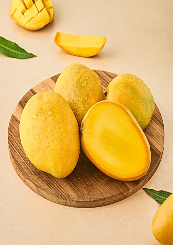 Fresh Banganapalli mangoes on a wooden plate